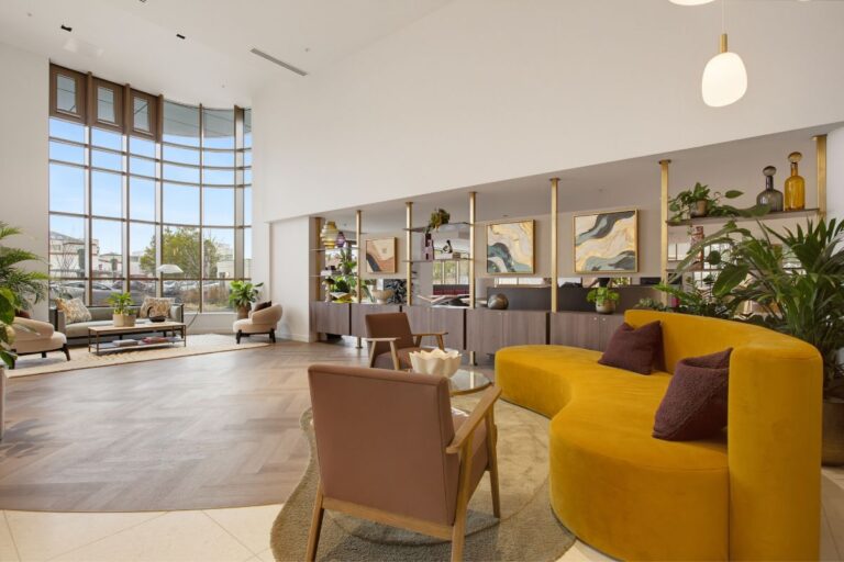 Spacious resident lounge at The Wiltern with seating, plants and floor-to-ceiling windows