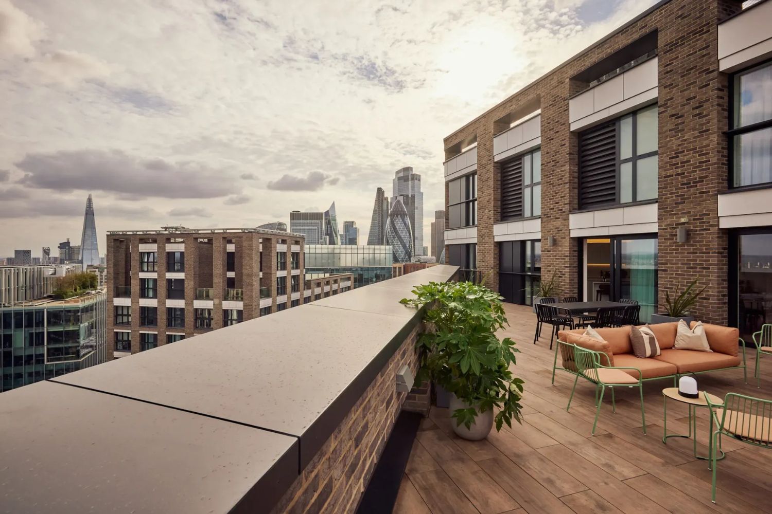 Roof terrace at Alma Aldgate overlooking the City of London skyline and The Gherkin