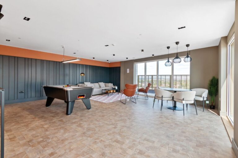 Residents lounge at Sutton Park House with pool table, seating areas and floor to ceiling windows