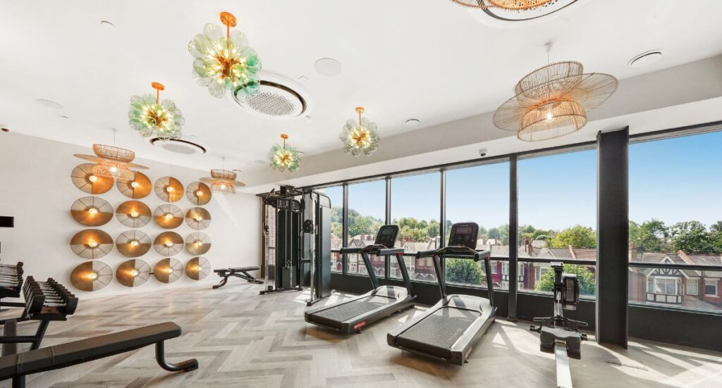 Fully equipped gym with treadmills and large windows overlooking Harrow