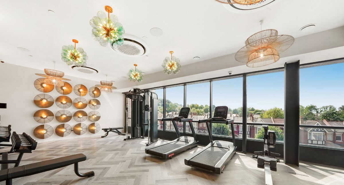 Fully equipped gym with treadmills and large windows overlooking Harrow