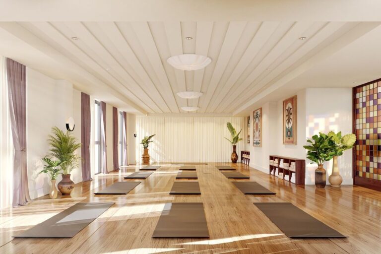Calm yoga studio with wooden floors, mats laid out, and natural light through tall windows
