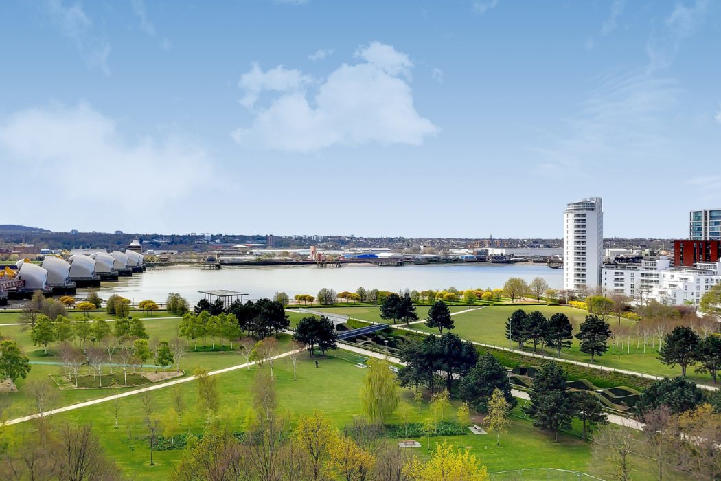 Elevated view across Thames Barrier Park with river and surrounding buildings