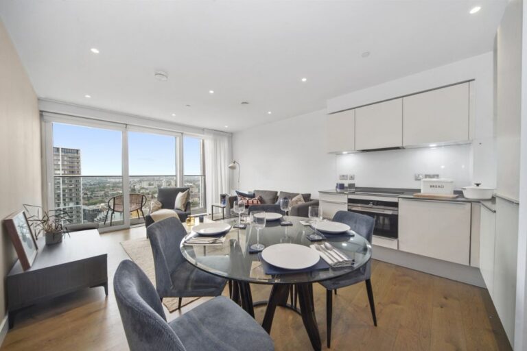 Modern kitchen with integrated appliances and dining table set for four