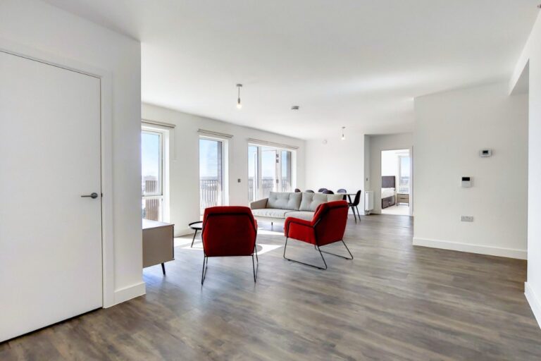 Spacious open plan living room with sofas, chairs and multiple windows