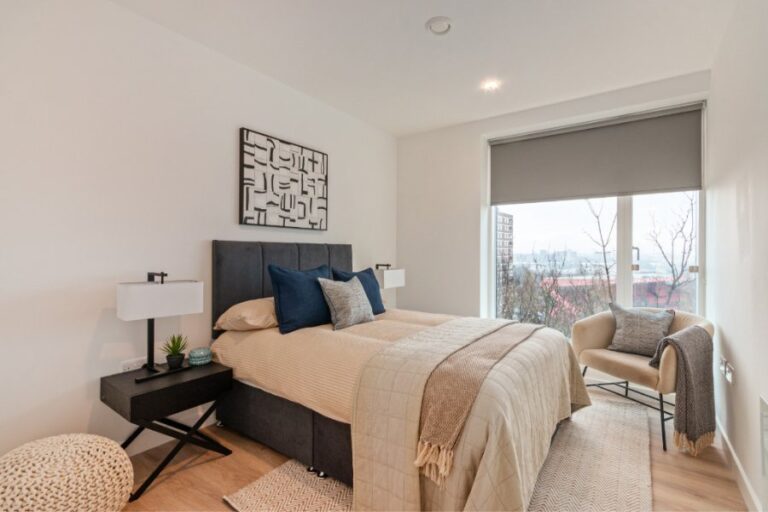 Bedroom inside The Heights apartment with large windows and natural light