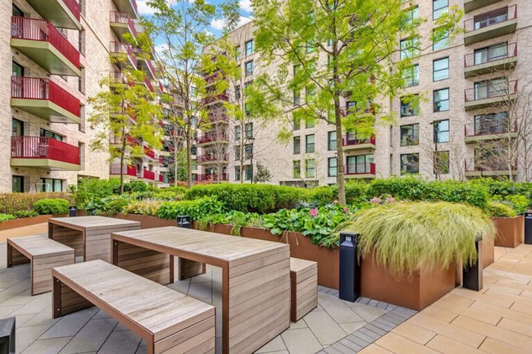 Communal outdoor courtyard with planting, seating and residential buildings surrounding