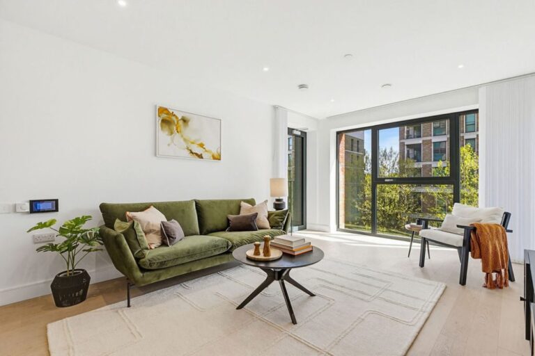 Bright living room with modern furnishings and large windows overlooking landscaped surroundings