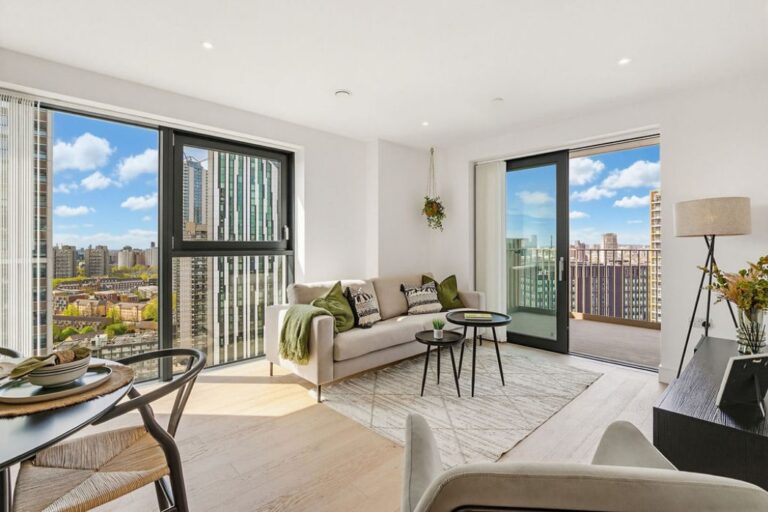 Living area with large windows and access to private balcony overlooking surrounding buildings