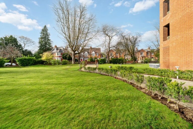 Well maintained communal gardens with lawn, pathways and surrounding residential buildings