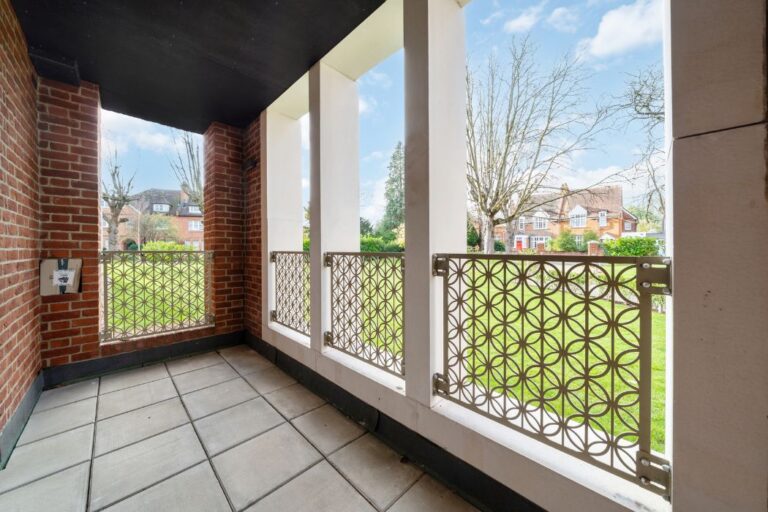 Private balcony with decorative metal railings overlooking landscaped gardens