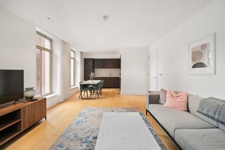 Bright open plan living room with dining space, large windows and wooden flooring