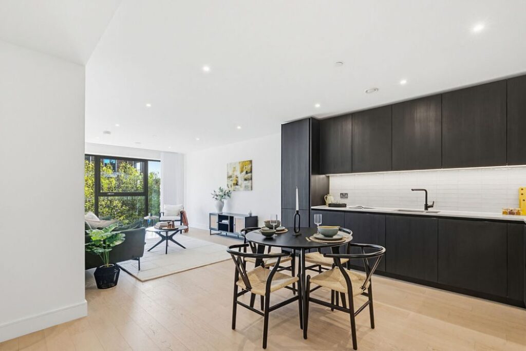 Open plan living area with kitchen, dining space and large windows