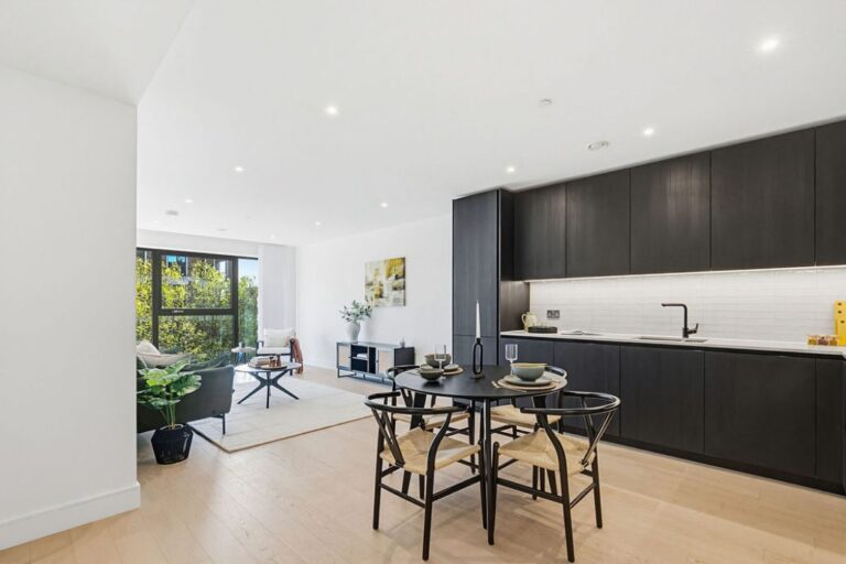 Open plan living area with kitchen, dining space and large windows