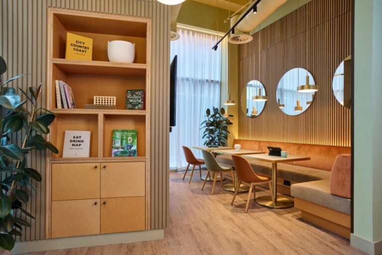 Co working lounge at Fortunes Dock apartments with seating booths tables and modern shared workspace