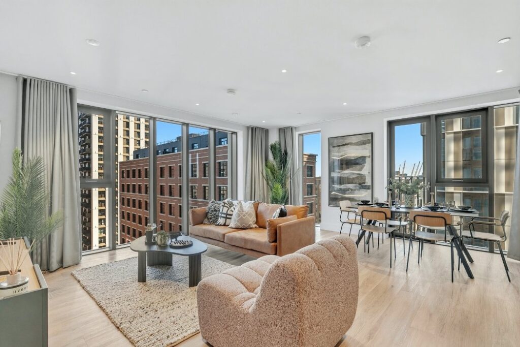 Open-plan living and dining room in an apartment at 50-60 Charter Street, with floor-to-ceiling corner windows and views across the Wood Wharf neighbourhood