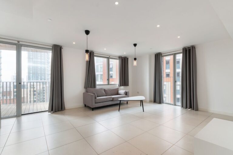 Open plan living area with balcony inside Rehearsal Rooms apartments in North Acton