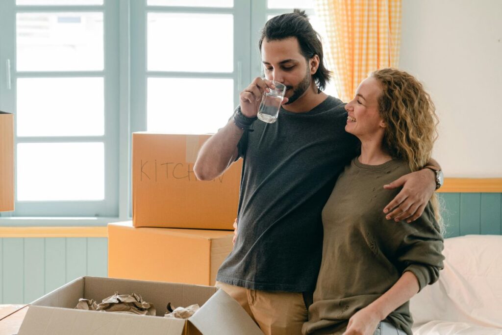 Young couple unpacking boxes as they move into their new London apartment