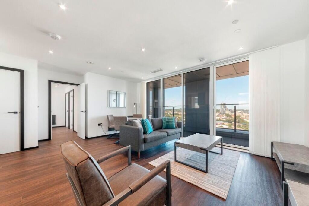 Bright open-plan living room with floor-to-ceiling windows and private balcony at Westgate House, Ealing