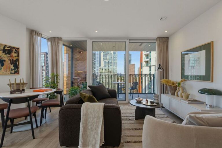 Modern living and dining room at Apex One with floor-to-ceiling windows and private balcony