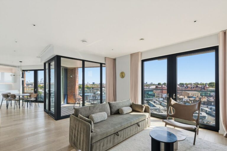 Spacious open-plan living and dining area with floor-to-ceiling windows and views across Camden