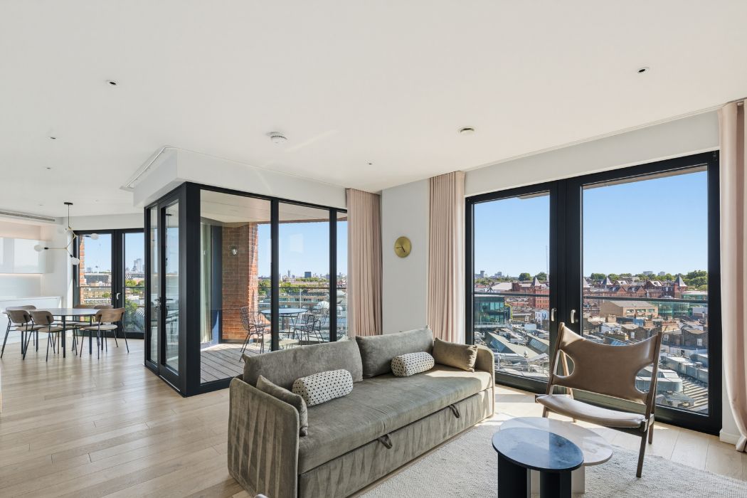 Spacious open-plan living and dining area with floor-to-ceiling windows and views across Camden