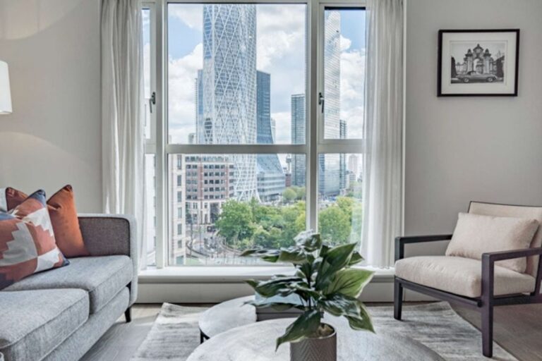 Living room at Circus Apartments with floor-to-ceiling windows overlooking the Canary Wharf skyline