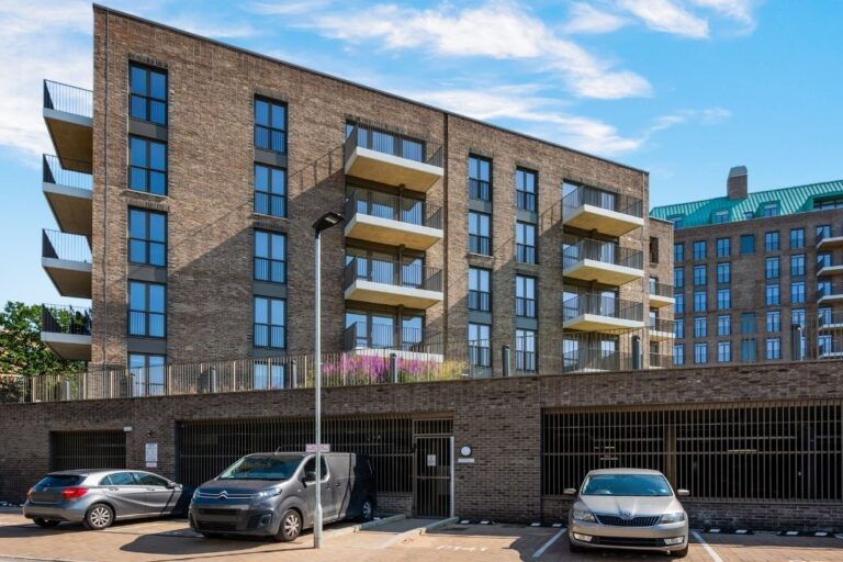 Modern apartment block with parking in front at Wolff House rental development