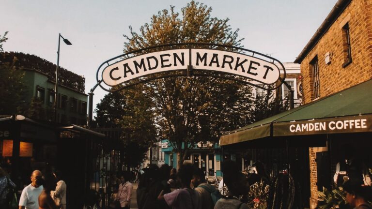 Camden Market entrance in Camden Town with visitors walking beneath the market sign