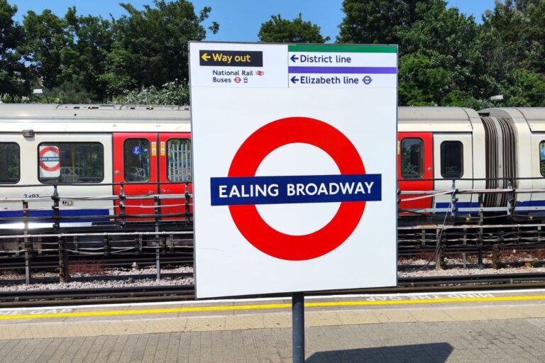 Platform at Ealing Broadway Station with signs to Elizabeth Line and District Line connections
