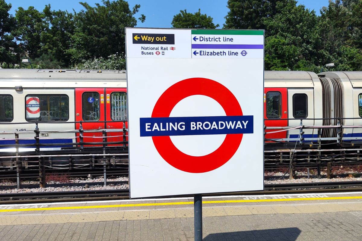 Platform at Ealing Broadway Station with signs to Elizabeth Line and District Line connections